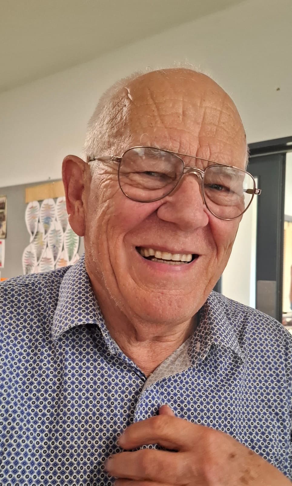David Hyslop, smiling, wearing glasses and a patterned shirt.